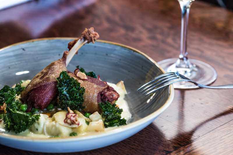 cooked duck leg dish on a ceramic plate